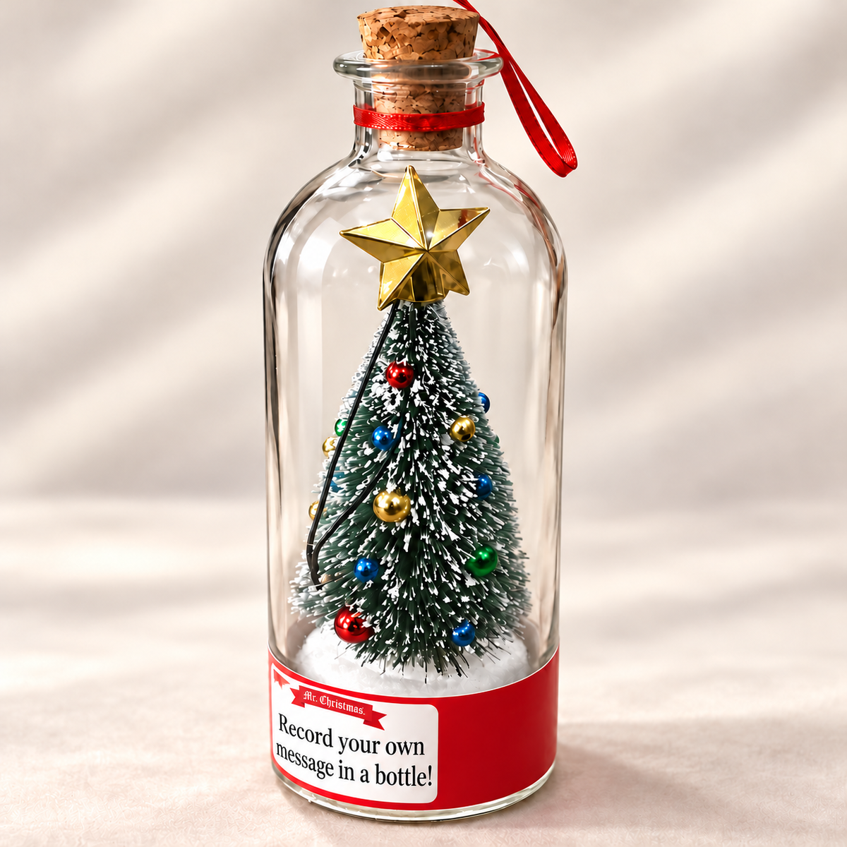Close-up of the tree, ornaments and gold star inside the glass bottle